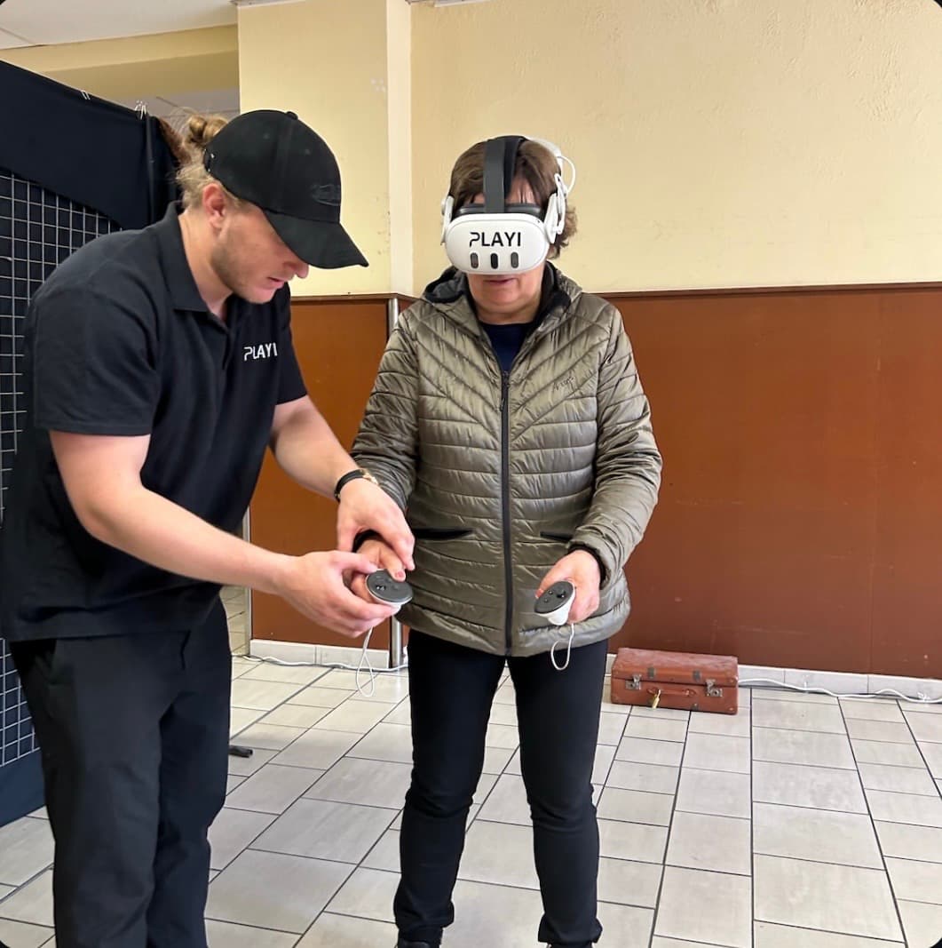 Une participante adulte accompagnée par un animateur PLAYI pendant une immersion VR